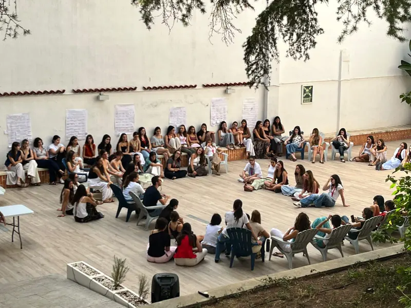 Residentes sentadas en círculo en el patio durante una actividad
