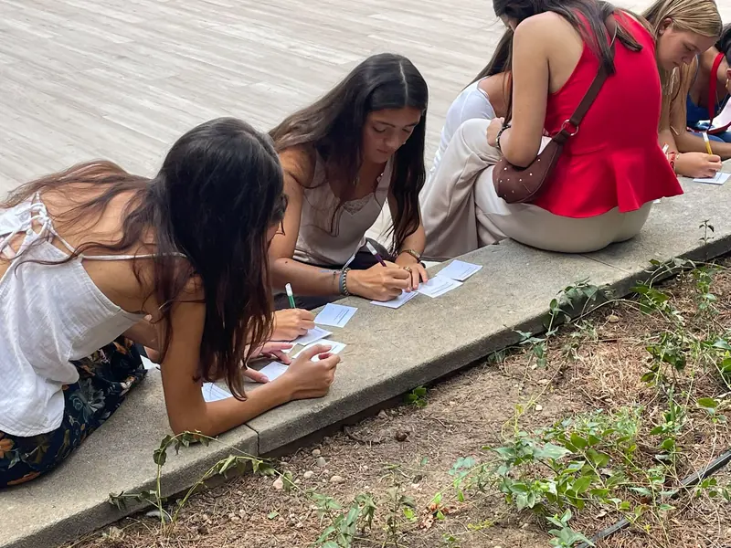 Residentes escribiendo durante una dinámica en el patio