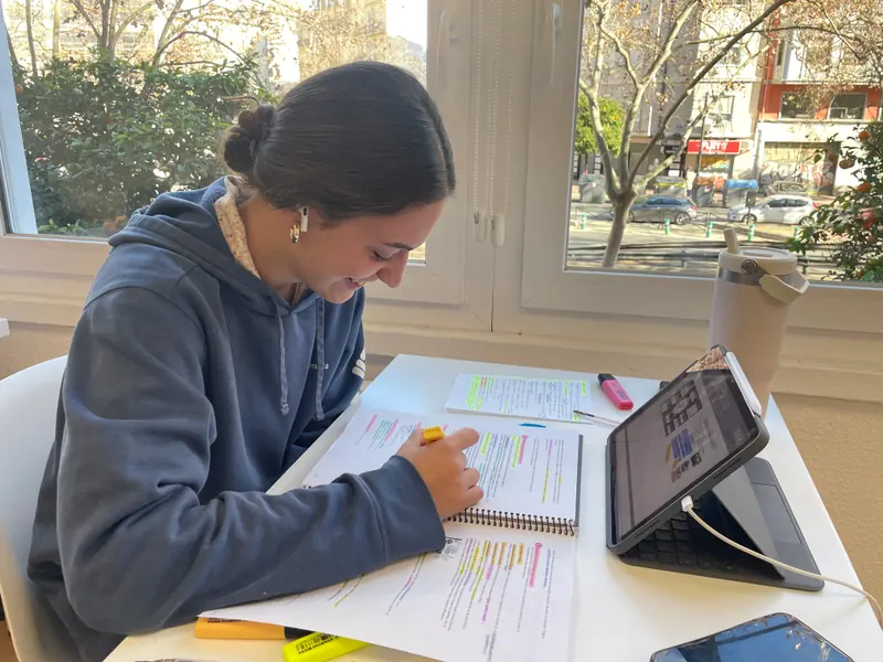 Una residente estudiando junto a la ventana